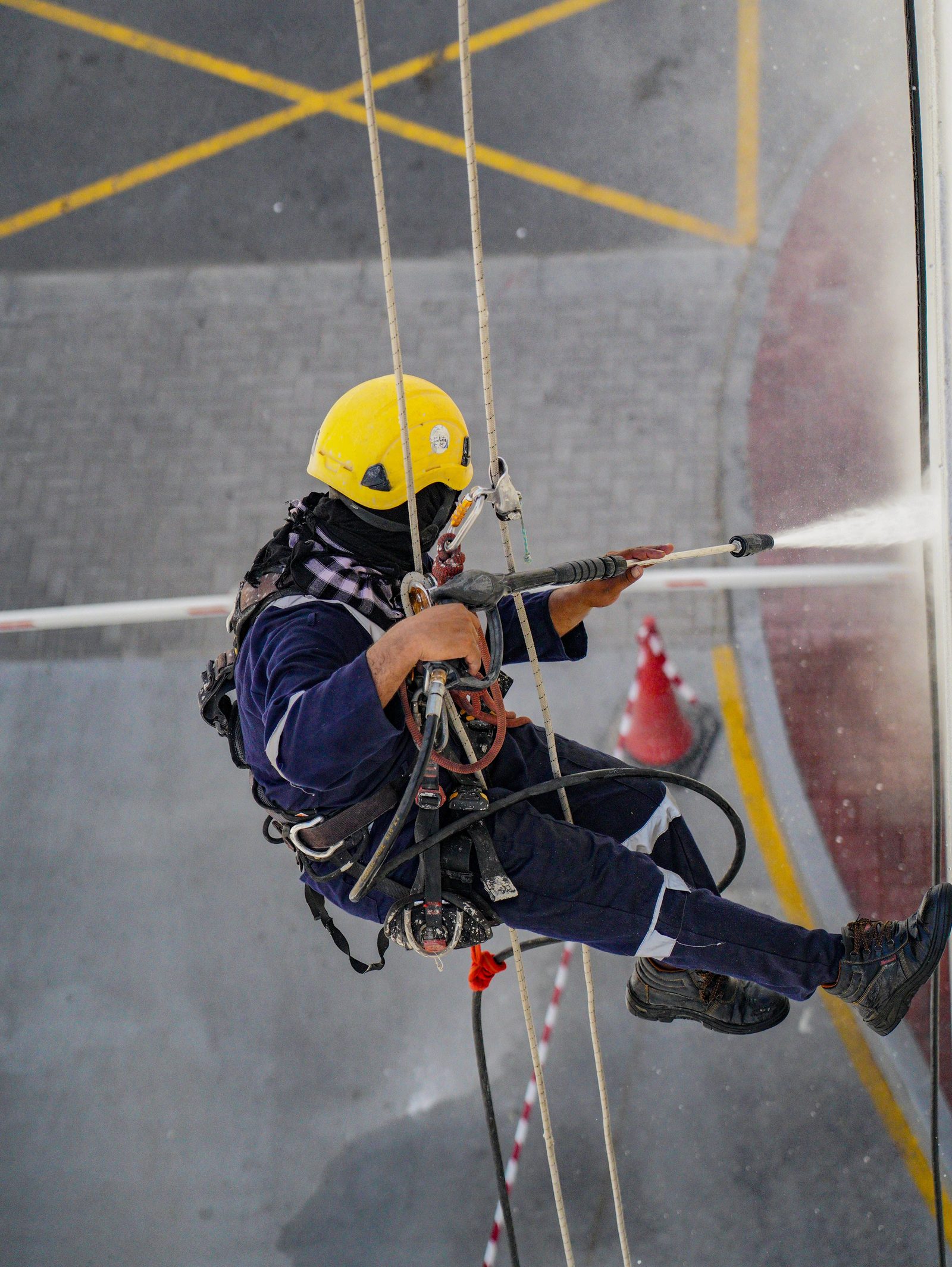 Rope access operative washing a commercial building facade